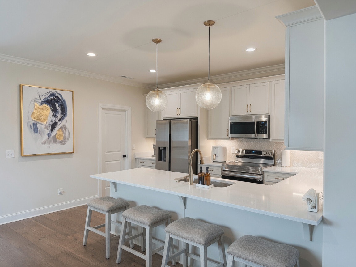 Staged kitchen with globe pendants and island seating